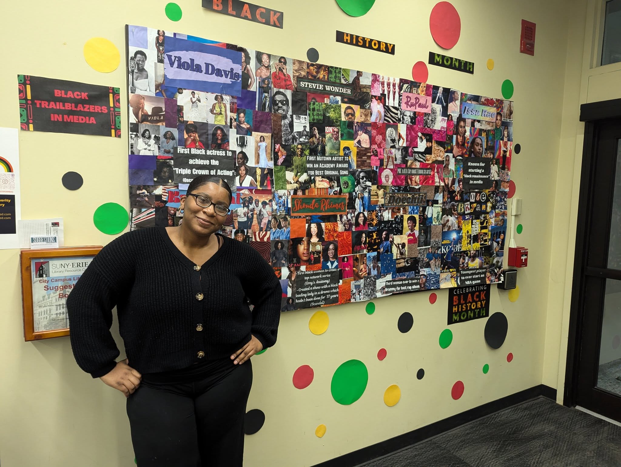 Kianna Brown standing infront of her Black History Month Collage at the Library